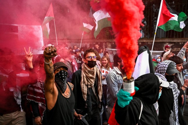 Pro-Palestinian demonstrators waves Palestinian flags and burn flares during a demonstration against Israel outside the 2025 Eurovision Song Contest's grand final in Basel on May 17, 2025. Protesters demonstrating against Israel's participation in the contest while it ramps up its war in Gaza clashed briefly with police in the centre of the city shortly before Israel's Eurovision entrant took to the stage at the St. Jakobshalle venue across town. (Photo by SEBASTIEN BOZON / AFP) (Photo by SEBASTIEN BOZON/AFP via Getty Images)