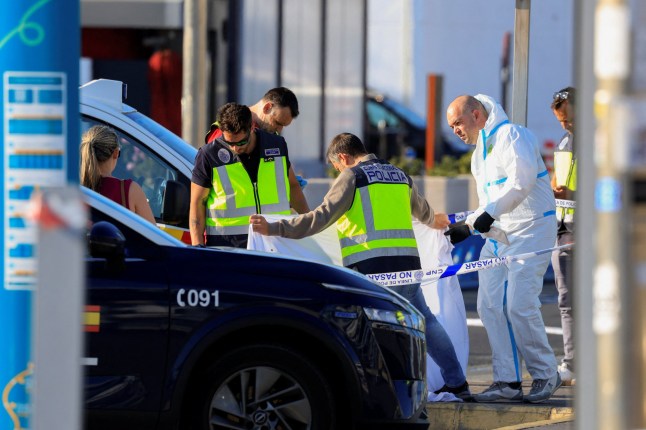 Spanish National Police officers observe the body of a man who was shot and killed by police during an intervention, outside Gran Canaria Airport, in Telde, Spain, May 17, 2025. REUTERS/Borja Suarez
