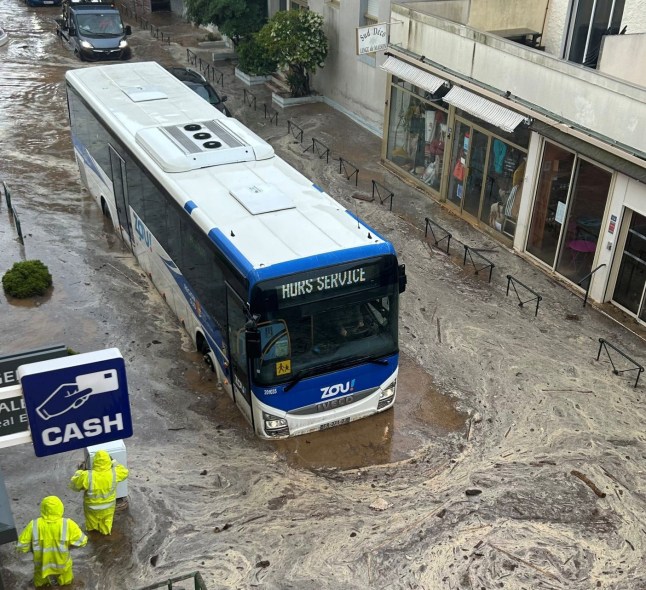 Bus partially submerged in floodwater.