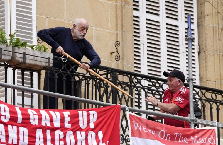 A local resident fending off Manchester United fans who are putting up banners above Plaza Nueva in Bilbao before the UEFA Europa League final at the Estadio de San Mames in Bilbao, Spain. Picture date: Wednesday May 21, 2025. PA Photo. See PA story SOCCER Final. Photo credit should read: Nick Potts/PA Wire. RESTRICTIONS: Use subject to restrictions. Editorial use only, no commercial use without prior consent from rights holder.