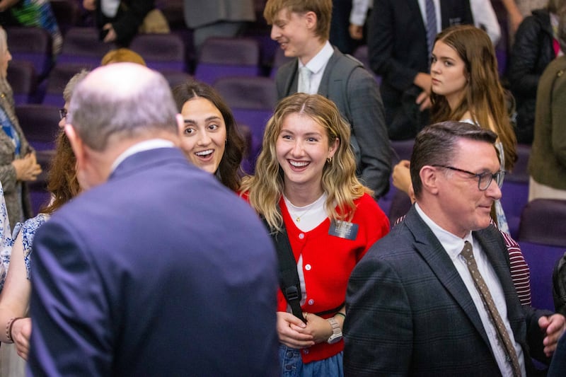 Sister missionaries greet Elder Quentin L. Cook of the Quorum of the Twelve Apostles at a multi-stake conference held in Birmingham, England on Sunday, May 25, 2025.