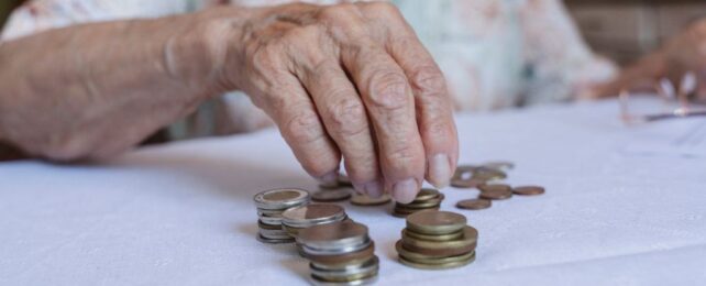 Hand of elderly person counting coins