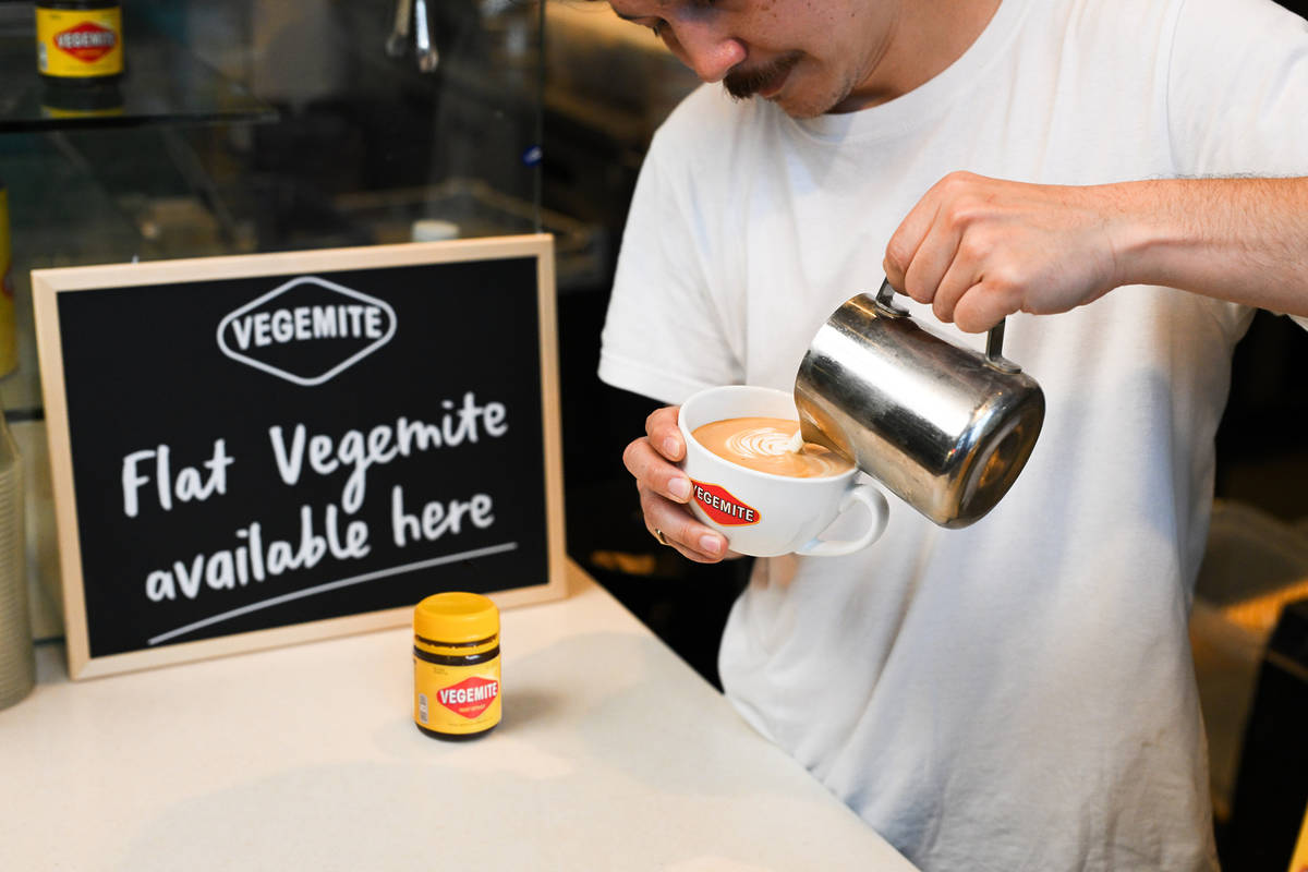 a barista making a vegemite flat white