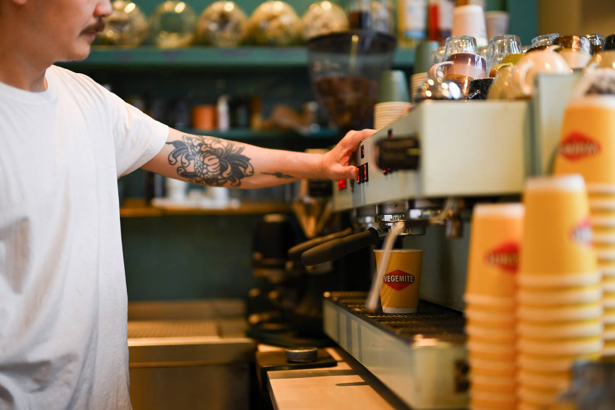 a barista pulling a shot of espresso at a coffee machine
