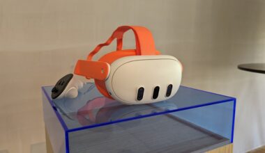 An orange Meta Quest 3 and its controllers on a blue plastic plinth in front of a blank wall
