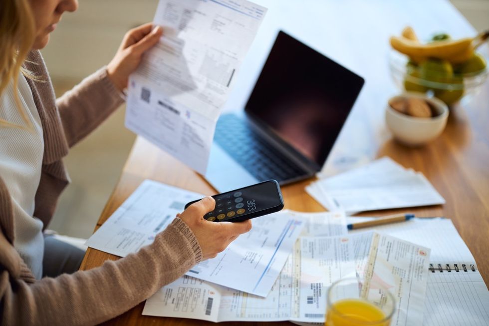 a women calculates her monthly bills using the calculator app on iPhone