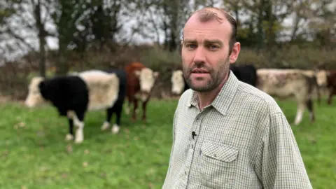 BBC A farmer with his herd of cattle