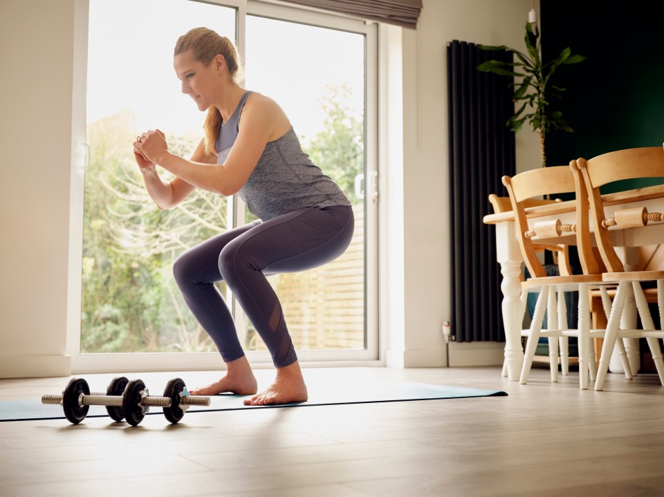 Woman doing squats at home.