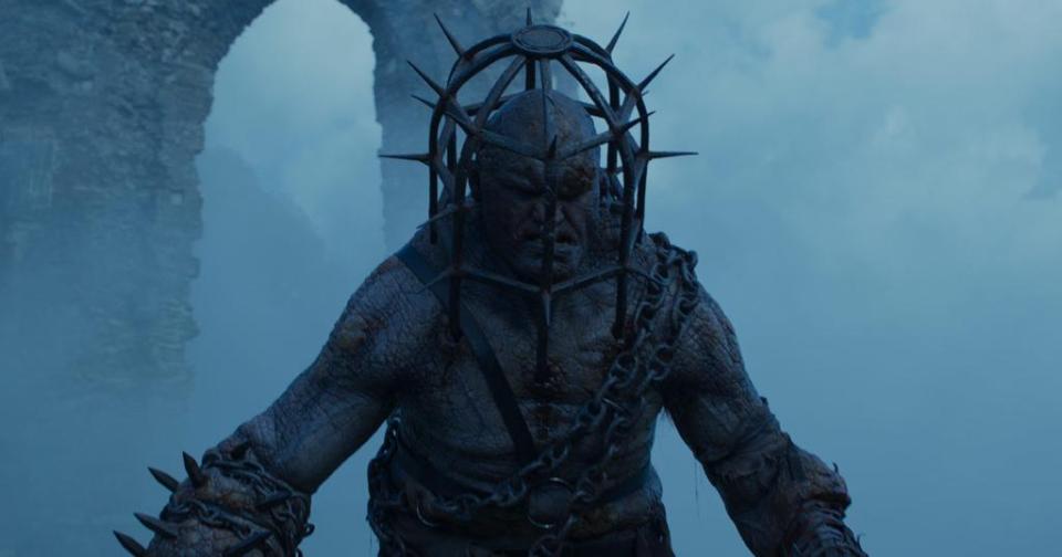 Ogre-like creature in chains and spiked cage.