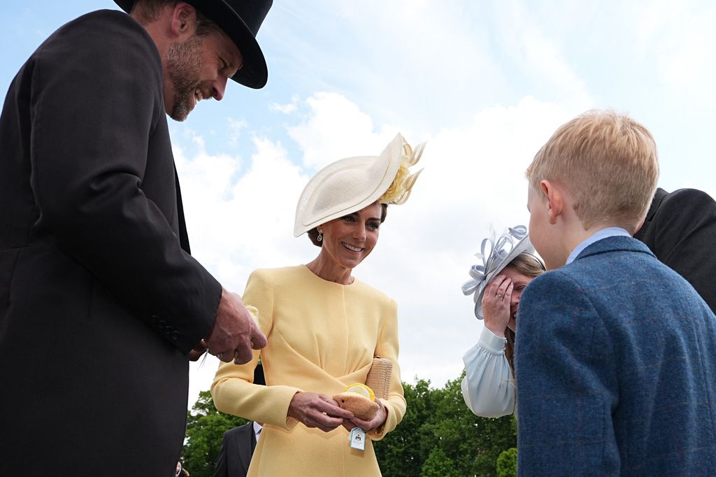 William and Kate smile at guests at garden party