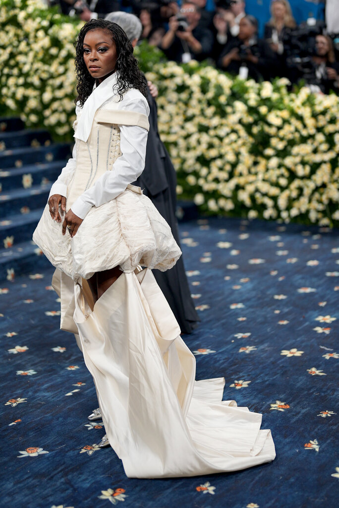 Danielle Deadwyler is wearing a cream dress over a white dress shirt.