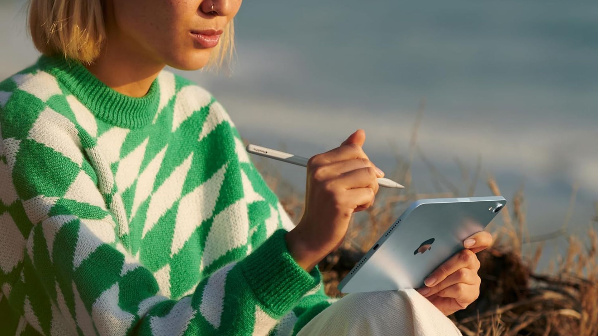 A woman taking notes on the Apple iPad Mini 7.