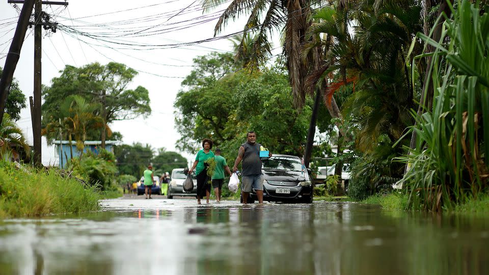 Residents wade through the flooded streets in Fiji's capital city of Suva on December 16, 2020, ahead of super Cyclone Yasa. - Leon Lord/AFP/Getty Images