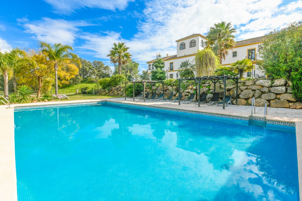 Swimming pool and Spanish-style house.