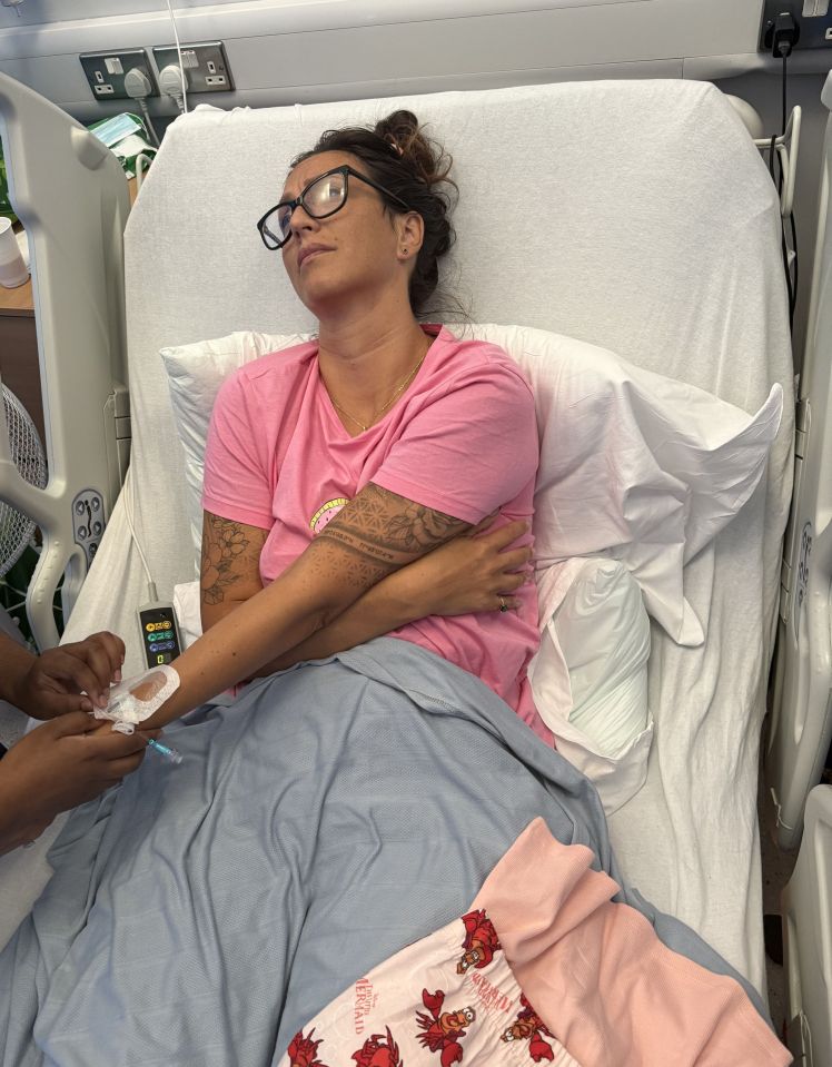 Woman in hospital bed receiving IV treatment.