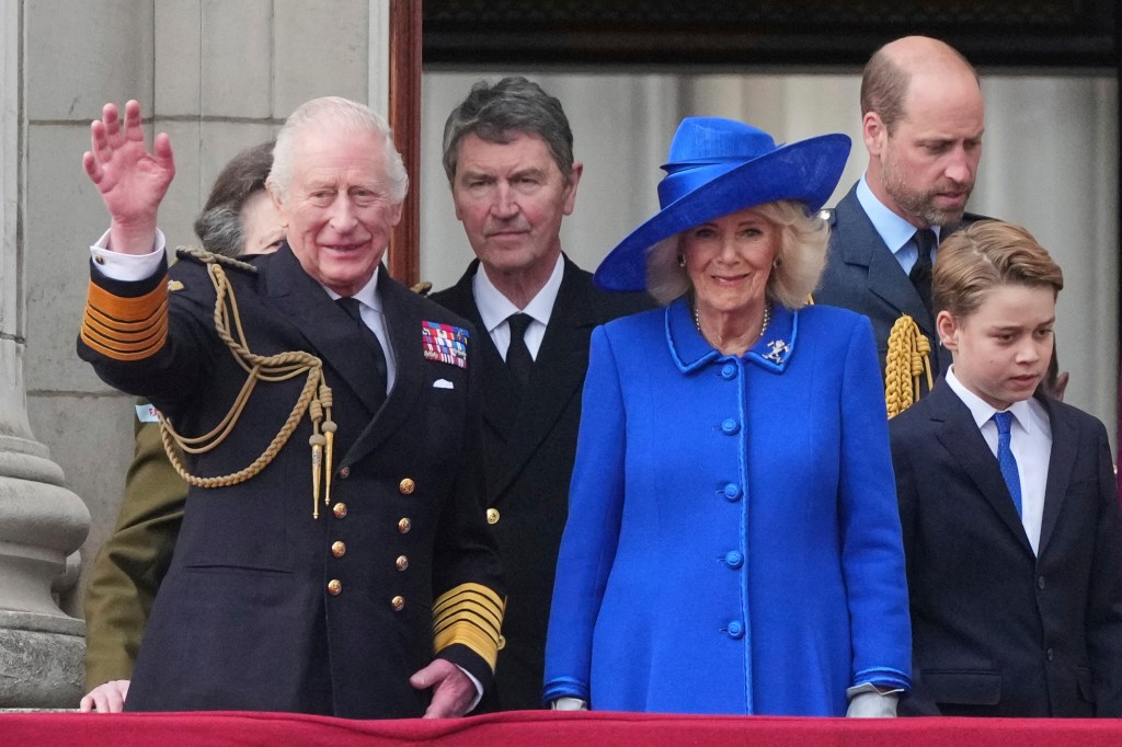 King Charles III and Queen Camilla waving to the guests below.