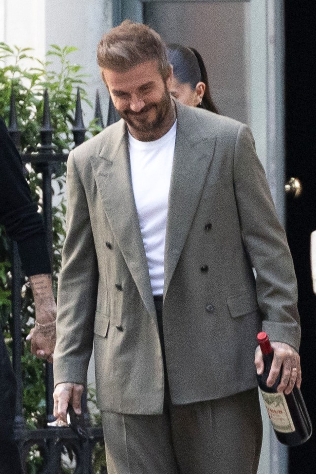 David Beckham carrying a bottle of wine.