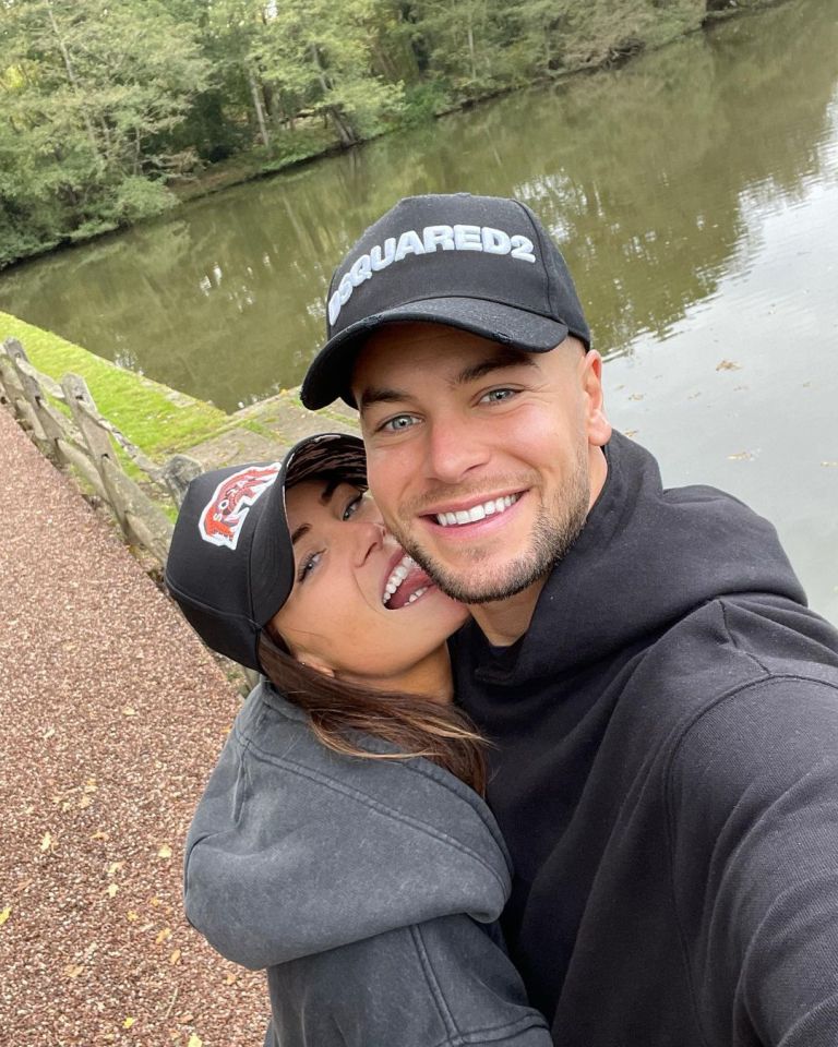 Chris Hughes and Annabel Dimmock embracing by a pond.
