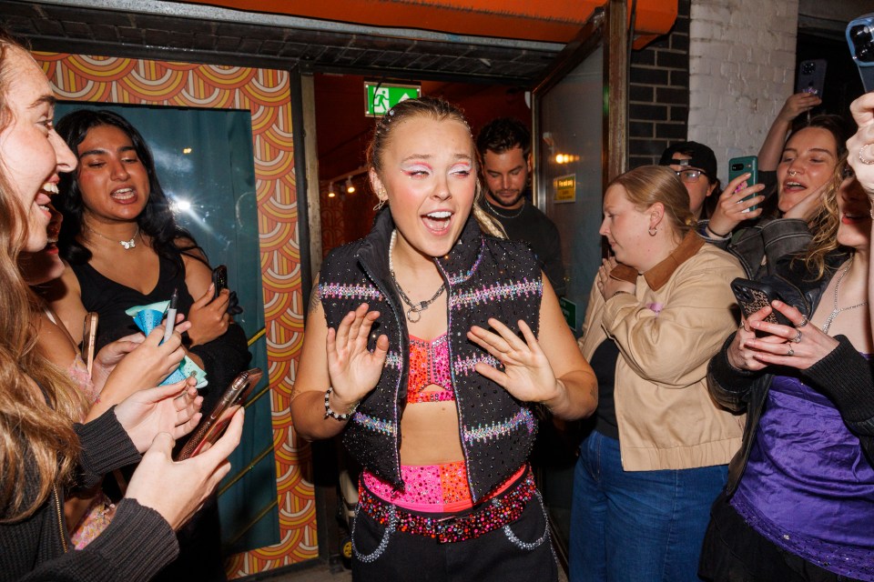 JoJo Siwa leaving a London venue, surrounded by fans.