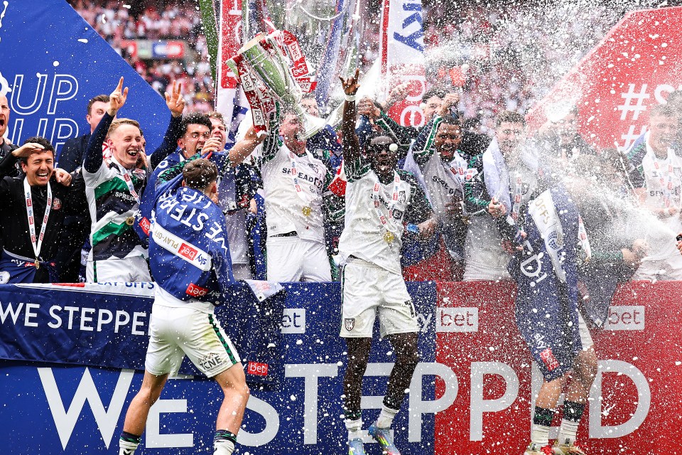 Sunderland players celebrating a championship victory with a trophy.