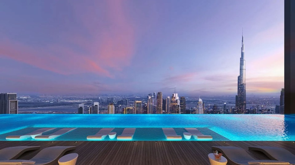 Infinity pool overlooking Dubai skyline at sunset.