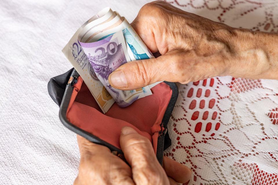 UK pound. A pensioner holds a wallet with money. Financial concept. Pensions in Britain
