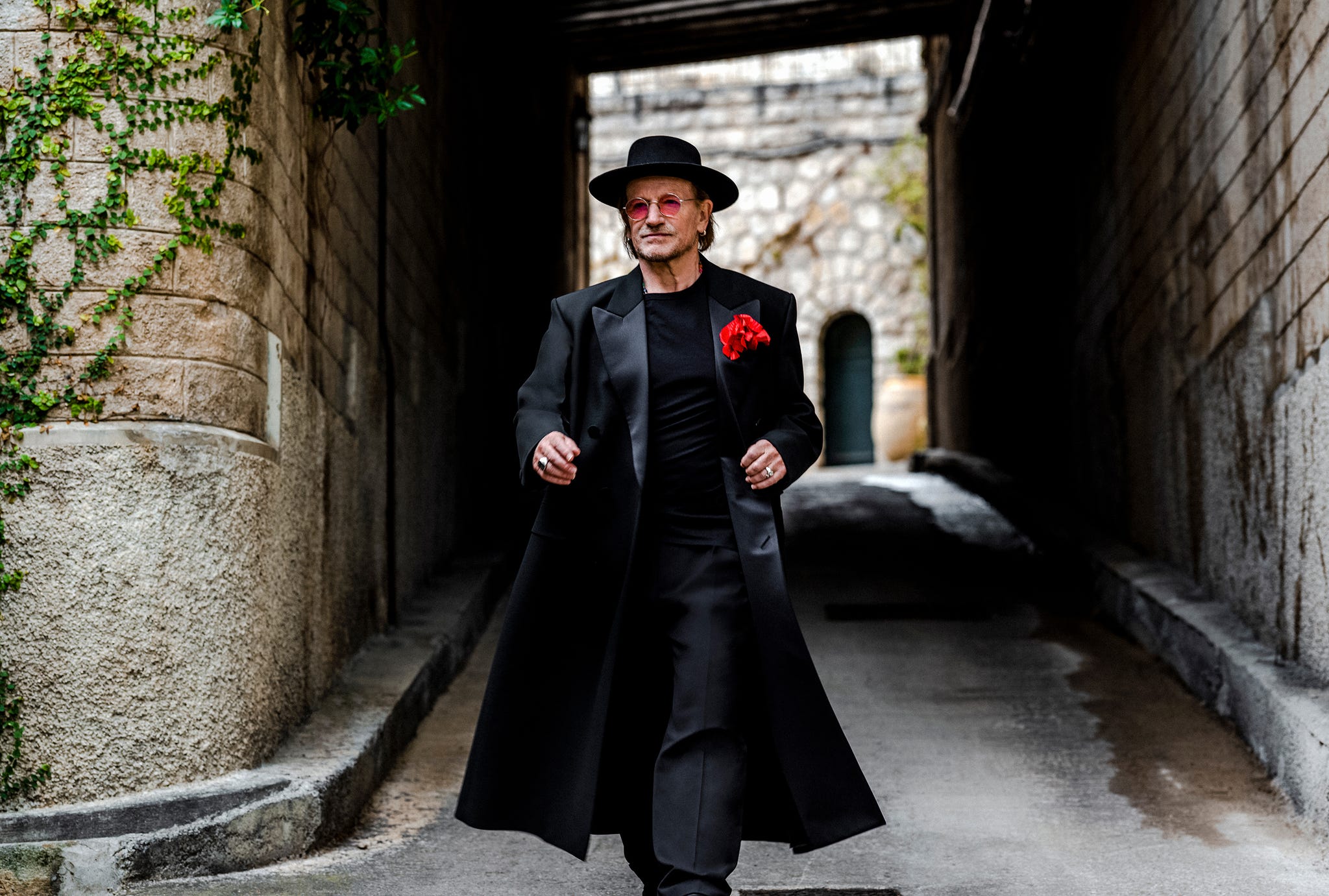 a stylish figure walking through a narrow alleyway