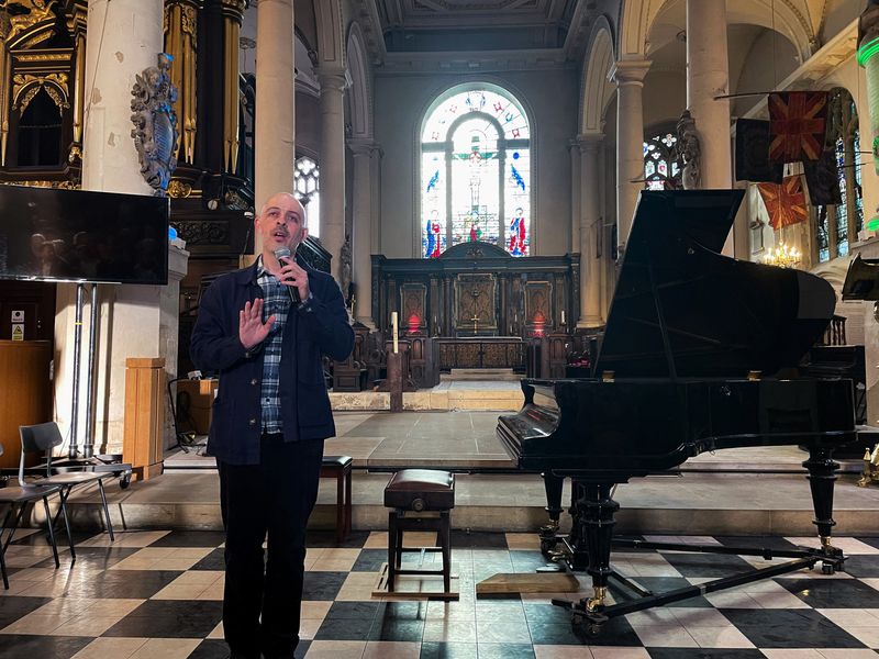 Russian film maker Roman Liberov addresses the audience at a concert he organised in memory of Pavel Kushnir, in London