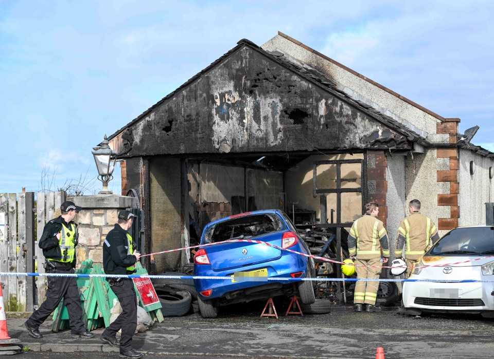 Firefighters and police officers at the scene of a fire at an industrial premises.