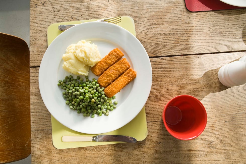 fish finger, mash potato and peas on dinner plate