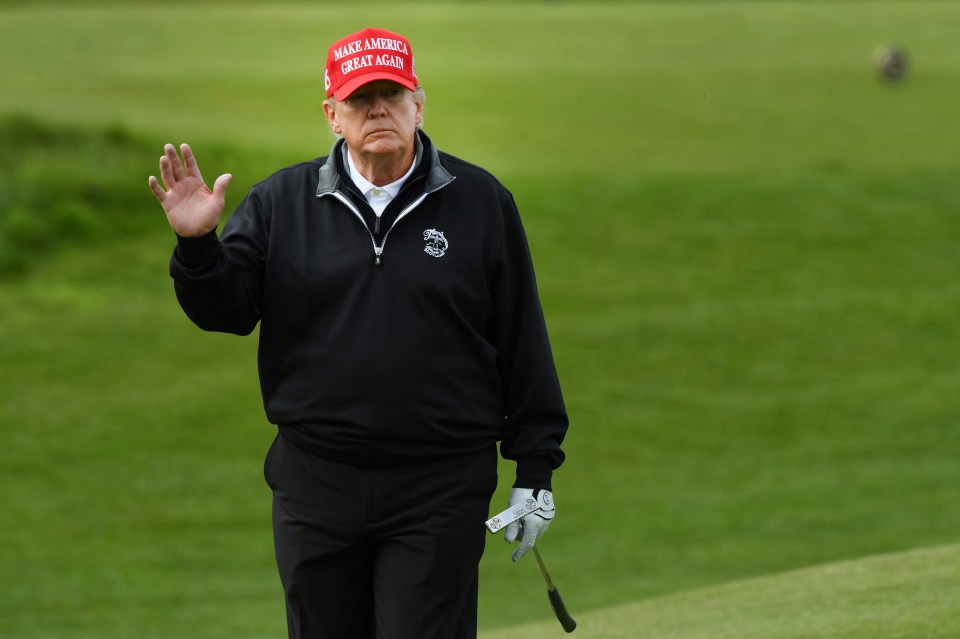 Donald Trump waving while playing golf.