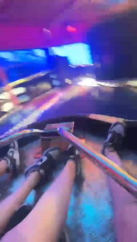 Person's legs and feet on a carnival ride.