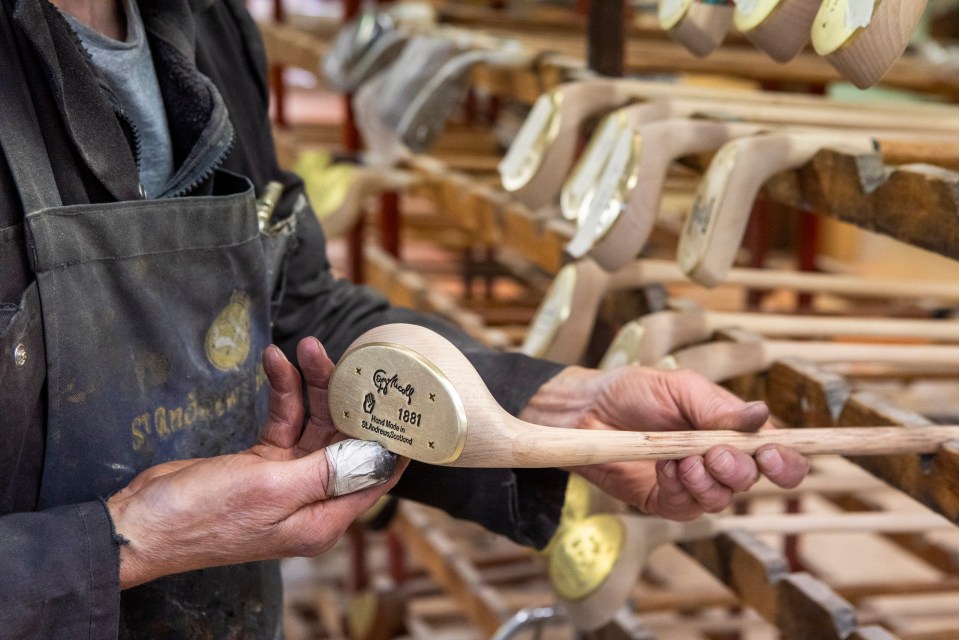 A craftsman holding a handcrafted golf club.