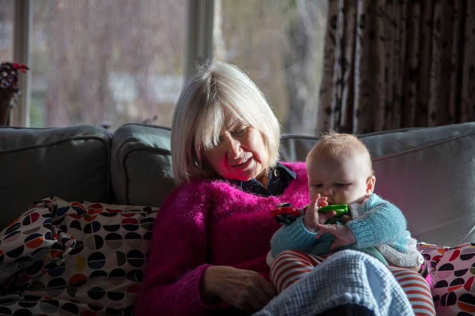 Grandparent and grandchild sitting on sofa together