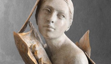 a sculpture of a woman's head and shoulders, surrounded by book or manuscript pages