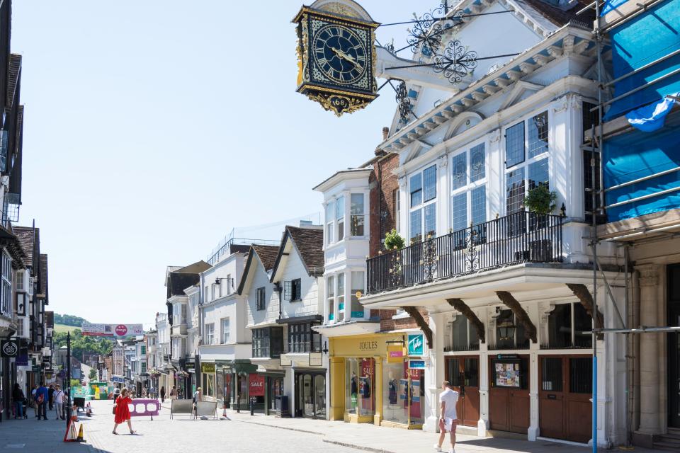 Guildford High Street in Surrey, England, with shops and a historic clock.