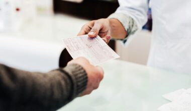 A person hands a paper prescription to another person across a counter