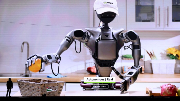 A video on a giant screen of a robot in a kitchen setting