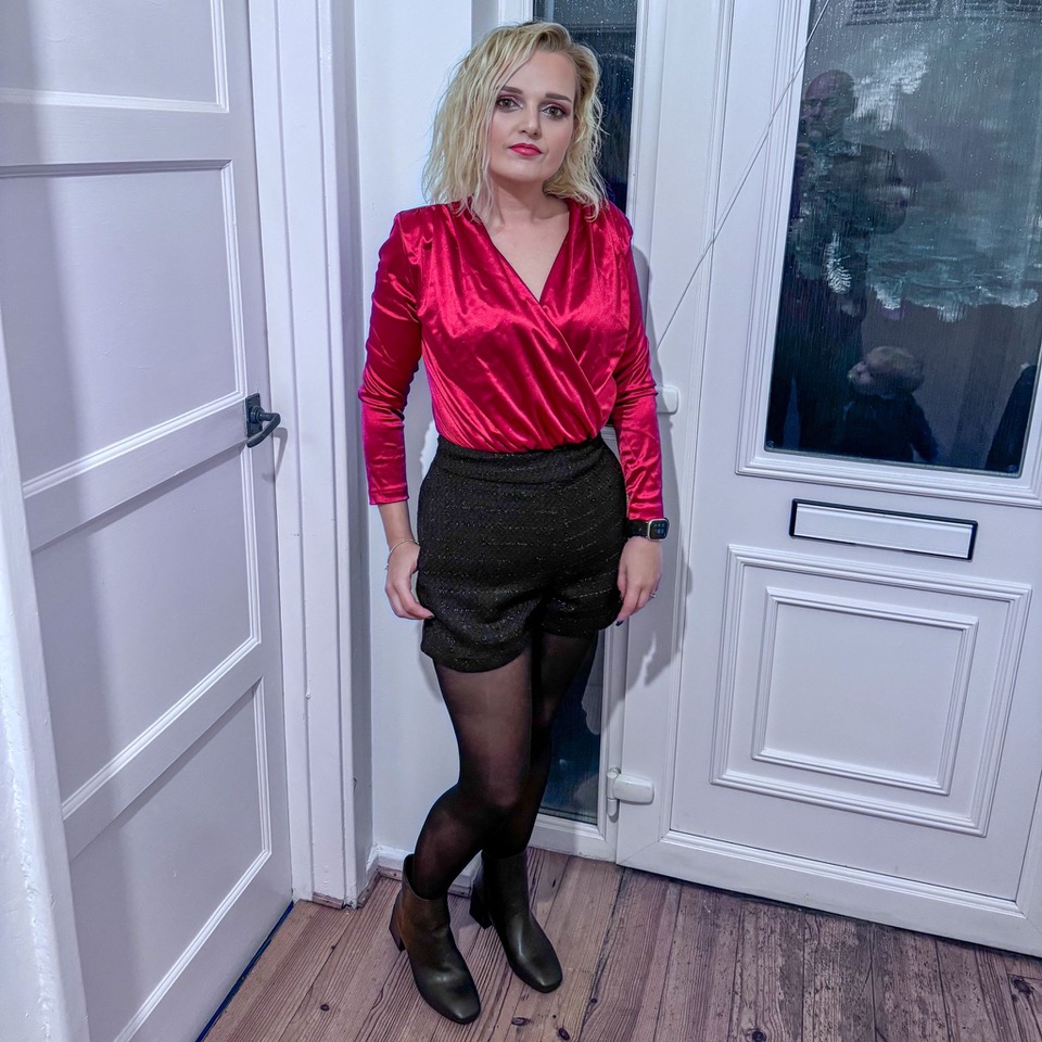 Woman in red top and black shorts.