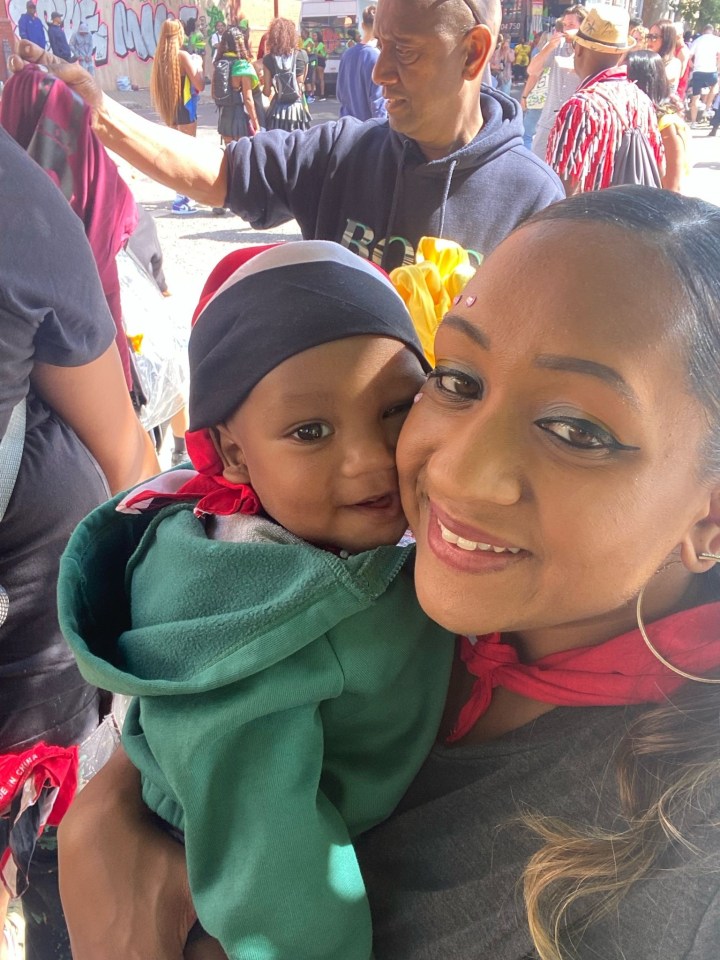 A woman holds a baby close to her face.