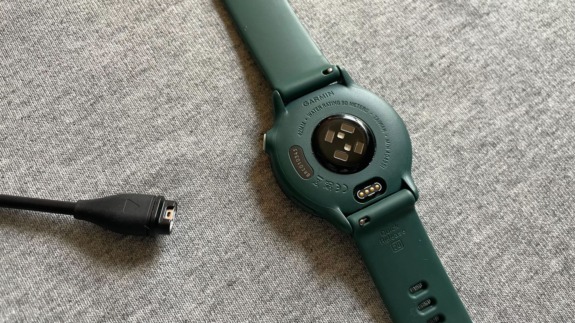 Back of Vivoactive 6 next to charger