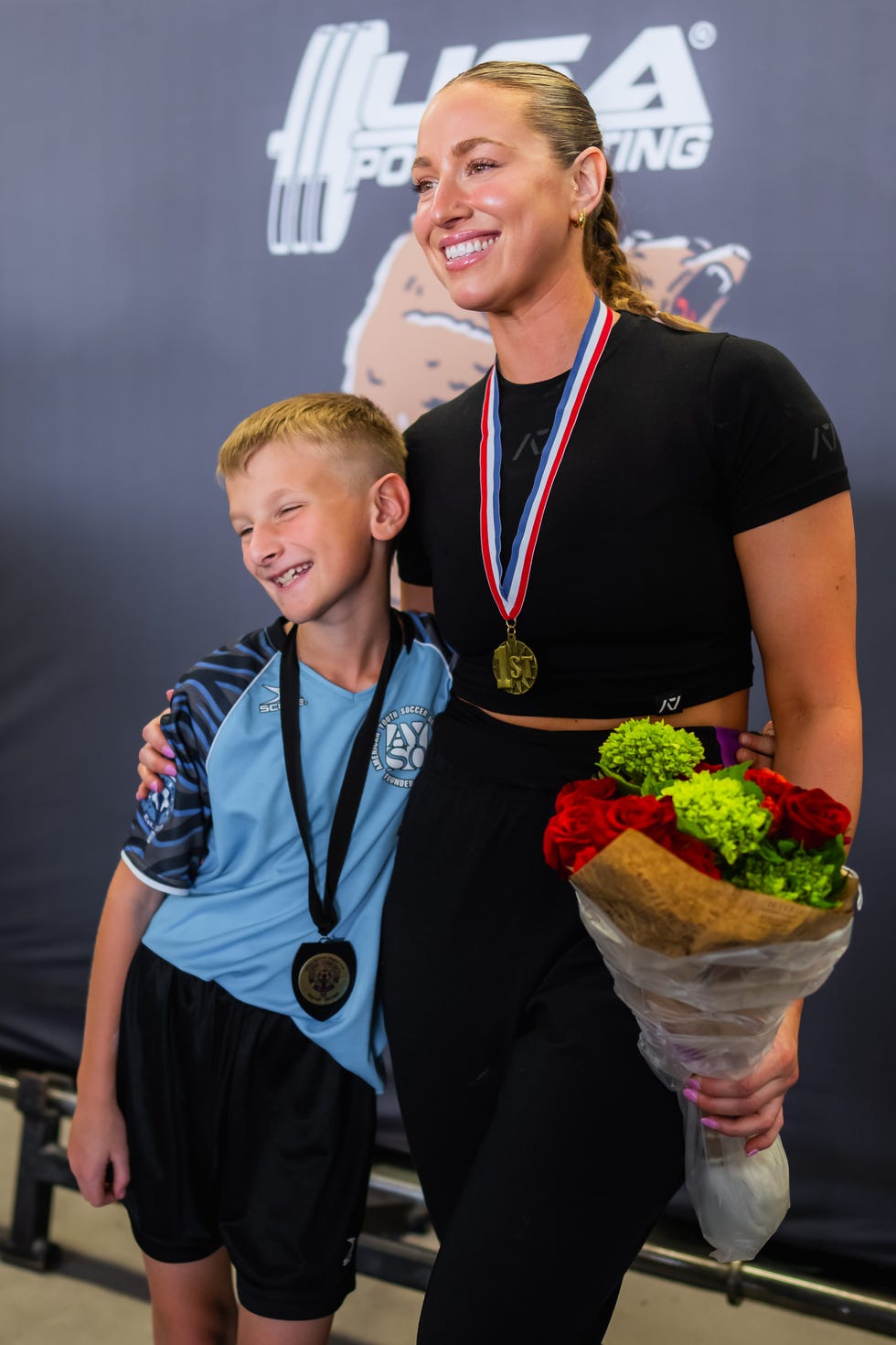 hailey with her son after competing in a powerlifting competition, 2023.