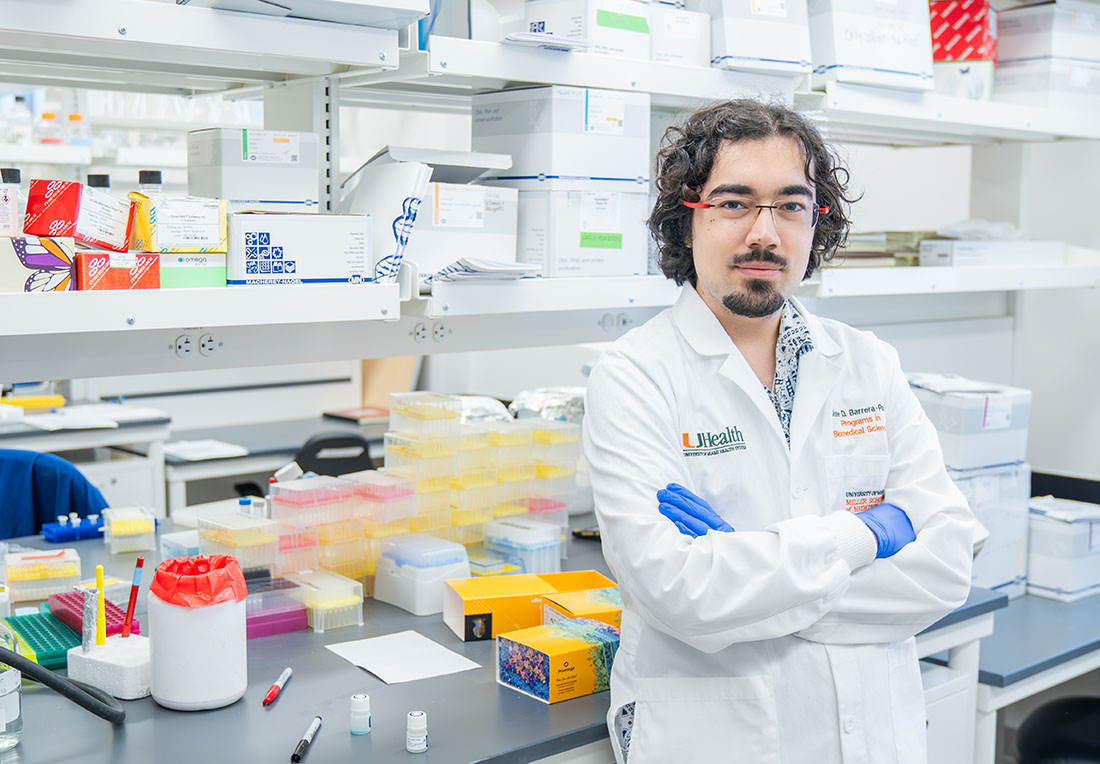 Dr. Jose Barrera-Paez in white clinic coat in his lab