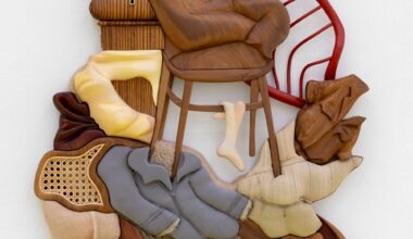 a mixed-media abstract wall sculpture with furniture and clothing forms