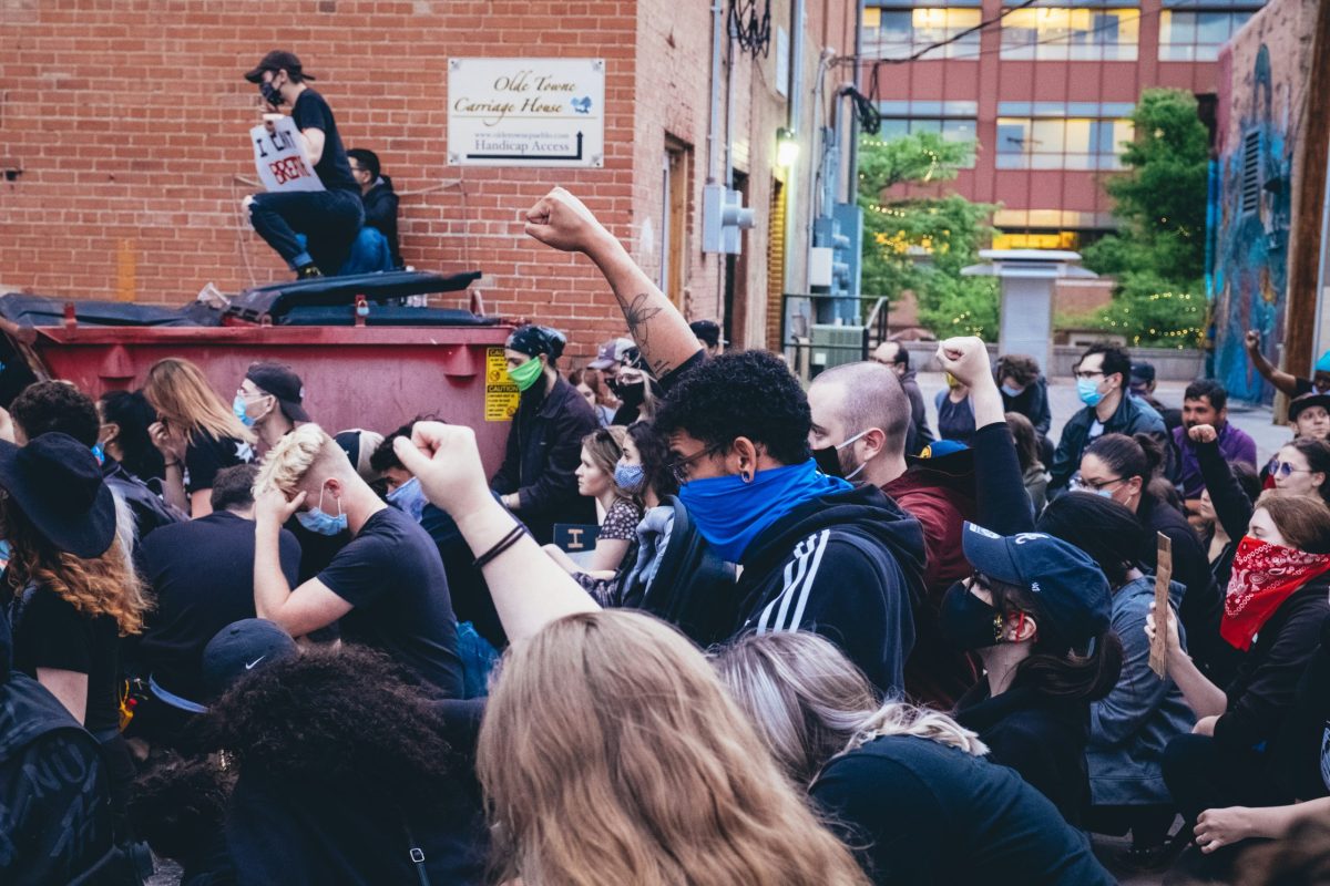 Masked people with their fists raised in a form of protest