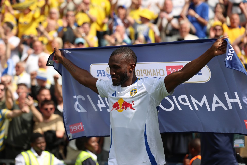 Josuha Guilavogui of Leeds United holding a championship banner.