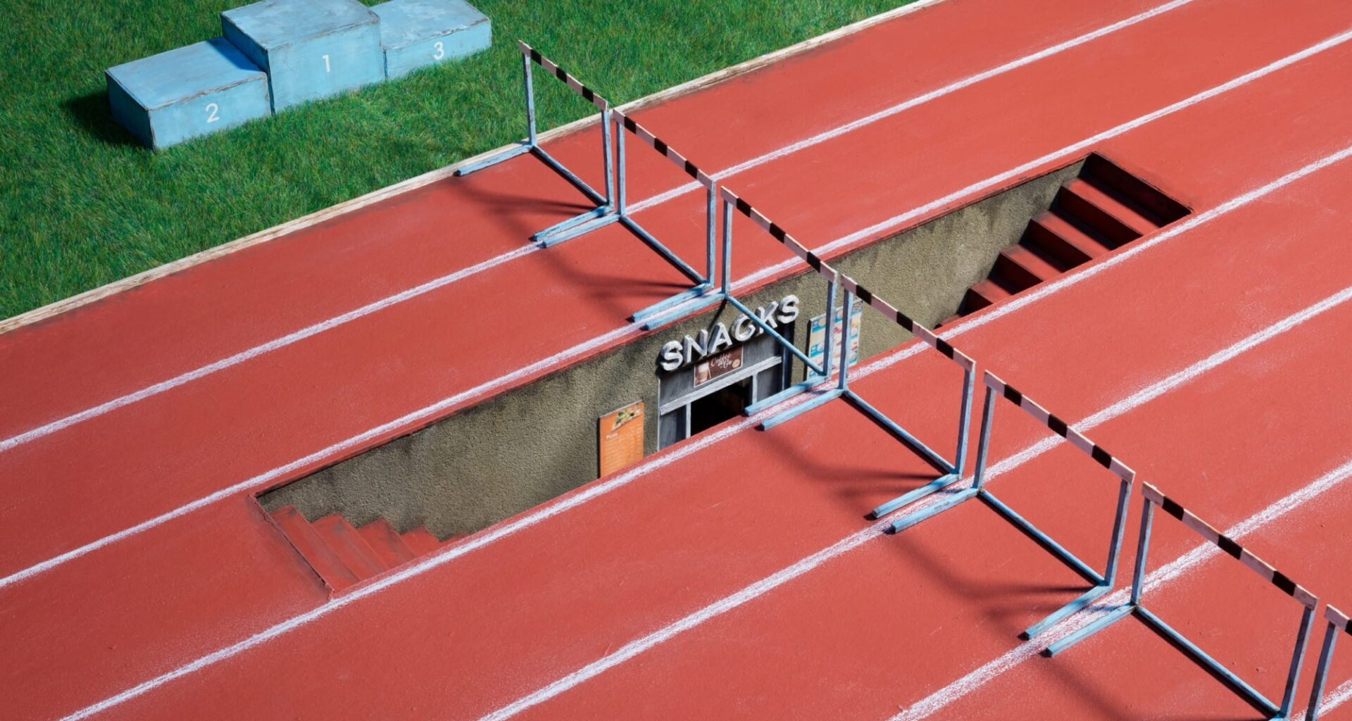 a photograph of a miniature sculpture construction of a running track with stairs leading downward in one of the lanes