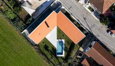 sculptural chimney pierces L-shaped house by martins architecture office in portugal