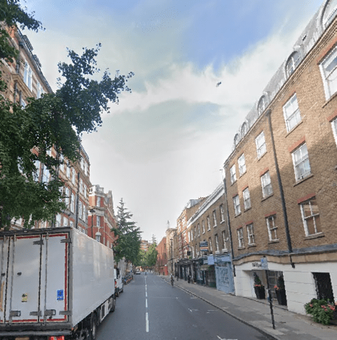 Street scene with brick buildings and a delivery truck.