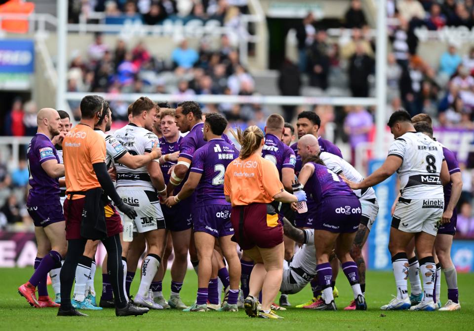 Rugby players surrounding an injured player on the field.